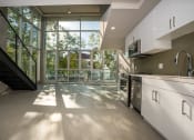 Thumbnail 50 of 89 - a kitchen with white cabinets and a large window