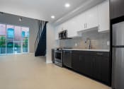 Thumbnail 52 of 89 - Downtown Los Angeles, CA Apartments - The Emerald - Kitchen with Quartz Countertops, White Soft-Close Cabinetry, Luxury Plank Flooring, and Stainless-Steel Appliances