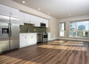 Thumbnail 54 of 89 - a kitchen and living room with hardwood floors and a large window