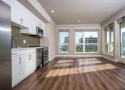 Thumbnail 55 of 89 - a kitchen and living room with hardwood floors and large windows