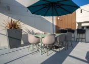 Thumbnail 59 of 89 - a terrace with a table and chairs and an umbrella