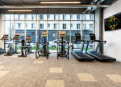 Thumbnail 72 of 89 - a large fitness room with cardio equipment and a large window