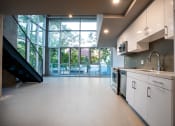 Thumbnail 82 of 89 - a kitchen with white cabinets and a large window