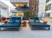 Thumbnail 83 of 89 - a seating area with blue couches and a black and white umbrella