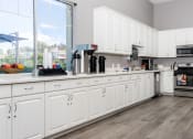 Thumbnail 21 of 34 - a large kitchen with white cabinets and a large window at 55+ FountainGlen Valencia, Valencia, California