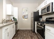 Thumbnail 1 of 34 - a kitchen with stainless steel appliances and white cabinets at 55+ FountainGlen Valencia, Valencia, California