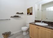 Thumbnail 9 of 28 - Compact bathroom with wooden side table at 55+ FountainGlen Grand Isle, Murrieta, CA 92562