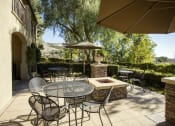Thumbnail 13 of 25 - a patio with a table and chairs and a fire pit at 55+ Remington at Ladera Ranch, California, 92694