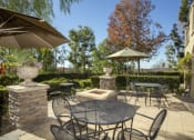 Thumbnail 12 of 25 - a patio with a firepit and tables and chairs at 55+ Remington at Ladera Ranch, Ladera Ranch