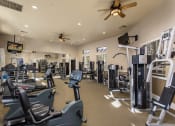 Thumbnail 22 of 25 - a spacious fitness center with cardio equipment and a flat screen tv at 55+ Remington at Ladera Ranch, California, 92694