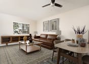 Thumbnail 4 of 34 - A living room with a brown couch, a coffee table, and a ceiling fan. at 55+ FountainGlen Terra Vista, Rancho Cucamonga