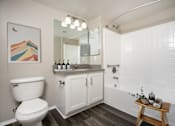 Thumbnail 8 of 34 - A bathroom with a toilet, sink, and a mirror. at 55+ FountainGlen Terra Vista, Rancho Cucamonga