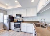 Thumbnail 26 of 28 - a kitchen with white cabinets and stainless steel appliances at Harbor Pointe, California