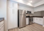 Thumbnail 31 of 45 - A kitchen with a stainless steel refrigerator, microwave, and oven.