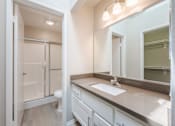 Thumbnail 37 of 45 - A bathroom with a sink, mirror, and shower.