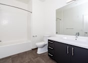 Thumbnail 20 of 68 - bathroom with white counter, large mirror and white tub and toilet at Imperial Hardware Lofts, California