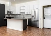Thumbnail 9 of 68 - kitchen with stainless appliances, white cabinets, stackable washer and dryer at Imperial Hardware Lofts, California