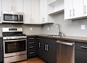 Thumbnail 13 of 68 - Kitchen with white upper cabinets and stainless appliances at Imperial Hardware Lofts, Riverside, 92501