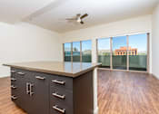 Thumbnail 21 of 68 - kitchen island and  livingroom with wood style floor and large windows at Imperial Hardware Lofts, Riverside, CA