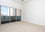 Thumbnail 19 of 68 - an empty living room with sliding glass doors to a balcony. at Imperial Hardware Lofts, Riverside, CA, 92501