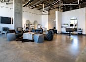 Thumbnail 25 of 68 - a living room with couches and tables in a warehouse at Imperial Hardware Lofts, California, 92501