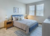 Thumbnail 13 of 83 - Studio Apartments In Burlingame, CA - Bayswater Burlingame - Spacious Bedroom With Plush Carpet Flooring, Area Rug, Bed, Nightstands With Lamps, Dresser, Wall Art, And Two Windows With Blinds at Baysw