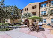 Thumbnail 41 of 123 - a patio with chairs and an umbrella in front of a building