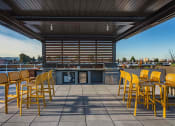 Thumbnail 31 of 83 - Rooftop Grill Area With Wood-Style Seating, City Views, And Gazebo-Style Covering. at Bayswater Apartments, Burlingame, CA