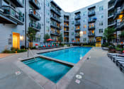 Thumbnail 28 of 34 - Resort-Inspired Pool With Lounge Chairs, Umbrellas, Spa, And Maintained Landscaping at Waterford RiNo, Denver