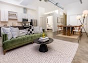 Thumbnail 42 of 68 - a living room with a green couch and a table at Imperial Hardware Lofts, Riverside, CA, 92501