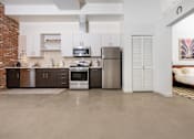 Thumbnail 43 of 68 - a kitchen with stainless steel appliances and white cabinets at Imperial Hardware Lofts, California, 92501