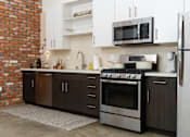 Thumbnail 46 of 68 - a kitchen with stainless steel appliances and white cabinets at Imperial Hardware Lofts, California, 92501