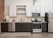 Thumbnail 47 of 68 - a kitchen with white cabinets and stainless steel appliances at Imperial Hardware Lofts, Riverside, CA, 92501
