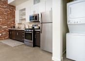 Thumbnail 48 of 68 - a kitchen with a washer and dryer and a refrigerator at Imperial Hardware Lofts, Riverside, CA, 92501