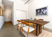 Thumbnail 51 of 68 - a dining room with a wooden table and chairs at Imperial Hardware Lofts, Riverside, 92501