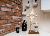 Thumbnail 53 of 68 - a christmas star hanging on a kitchen wall next to a brick wall at Imperial Hardware Lofts, California, 92501