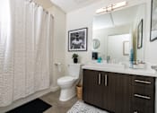 Thumbnail 58 of 68 - a bathroom with a shower and a toilet and a sink at Imperial Hardware Lofts, Riverside, CA