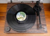 Thumbnail 59 of 68 - a record on a wooden table with a record player and a vinyl record on it at Imperial Hardware Lofts, Riverside
