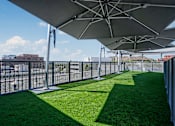 Thumbnail 4 of 68 - lounge area with grass and umbrellas at Imperial Hardware Lofts, Riverside, CA, 92501