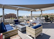 Thumbnail 5 of 68 - a rooftop patio with couches and chairs and a fire pit at Imperial Hardware Lofts, Riverside, CA
