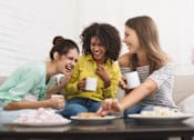 Thumbnail 17 of 80 - a group of women sitting on a couch eating food and drinking coffee