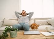 Thumbnail 17 of 123 - man on couch with dog listening to music on headphones