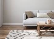 Thumbnail 20 of 60 - a living room with a white couch and a wooden coffee table in front of a gray wall