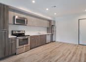 Thumbnail 2 of 26 - A modern kitchen with wooden cabinets and stainless steel appliances at Wilshire Valencia Apartment, California, 90017