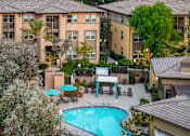 Thumbnail 60 of 80 - A pool surrounded by trees and umbrellas in a residential area.