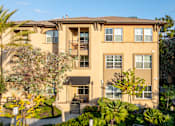 Thumbnail 62 of 80 - A large apartment building with a courtyard and trees.