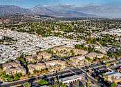 Thumbnail 69 of 80 - A residential area with houses and streets in the foreground and mountains in the background.