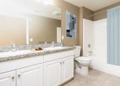 Thumbnail 7 of 80 - a bathroom with white cabinets and a blue shower curtain