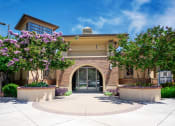 Thumbnail 2 of 80 - a building with an arched doorway and two large trees in front of it