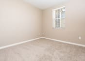 Thumbnail 37 of 80 - a bedroom with beige carpet and a window